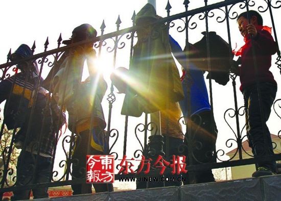 昨日，创新街小学操场，上体育课的孩子们难耐初春高温，将棉衣挂上护栏 东方今报首席记者 张晓冬 摄
